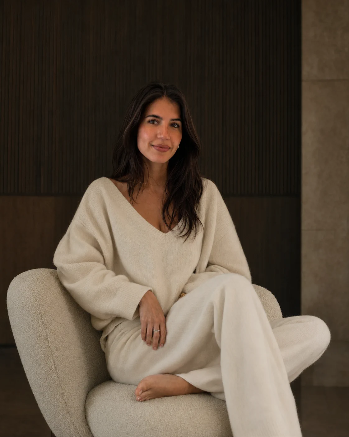 Mujer sentada en un interior cálido y minimalista al amanecer